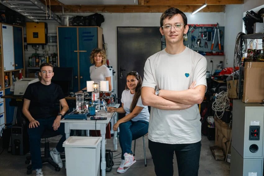 Piotr with three Kuuler teammates in their workshop, behind a table with the cooling panel prototype
